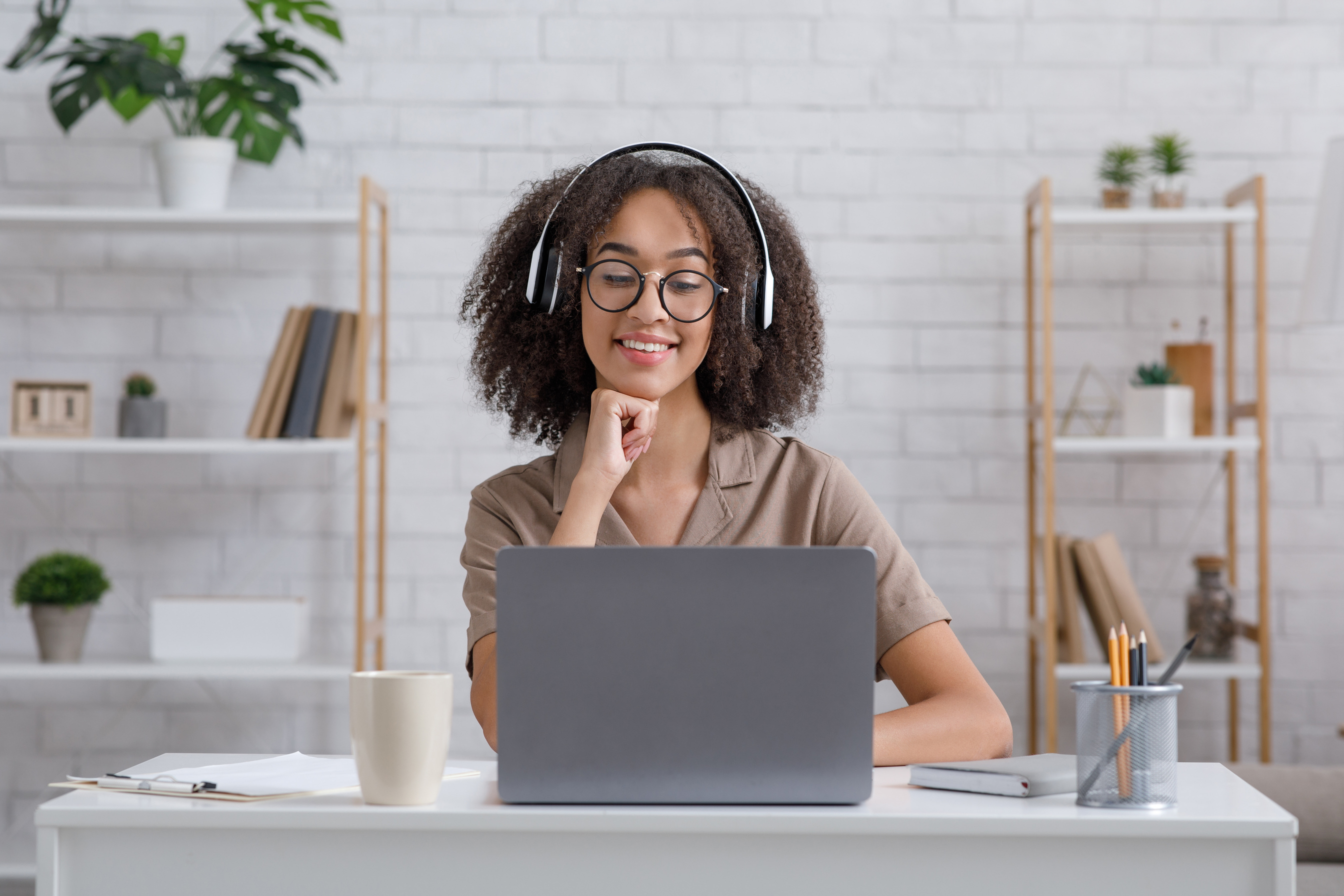 Distance education. Happy woman learn english, listen lecture with headphones and with looks in laptop